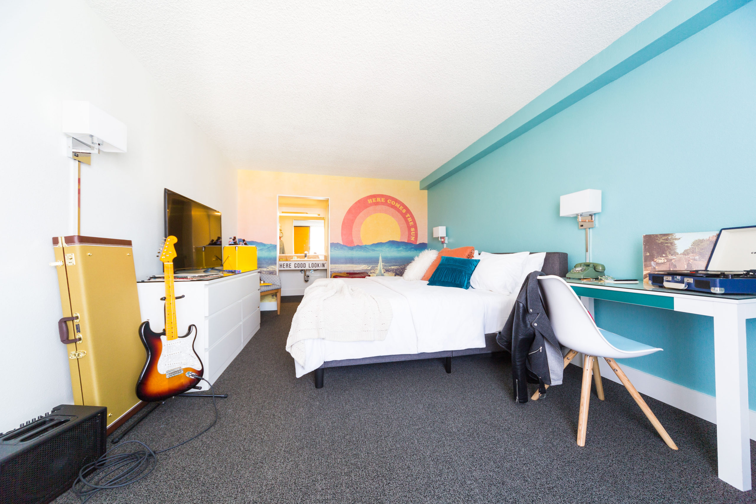 Here Comes the Sun Rambler Motel guestroom with record player and guitar set up